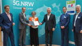 Bild 1: Minister Pinkwart überreicht die Urkunden an die Vertreter:innen der Projektpartner des CC5G.NRW [© FIR e. V. an der RWTH Aachen]
